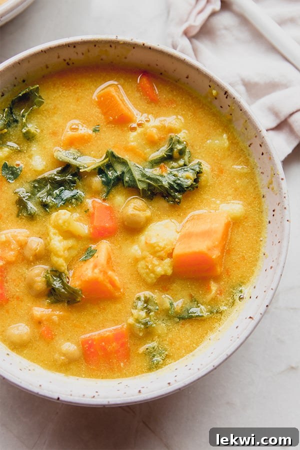 A beautifully presented bowl of golden chickpea and veggie soup, ready to be enjoyed.