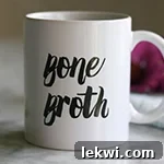 A white mug with text on it saying Bone Broth.