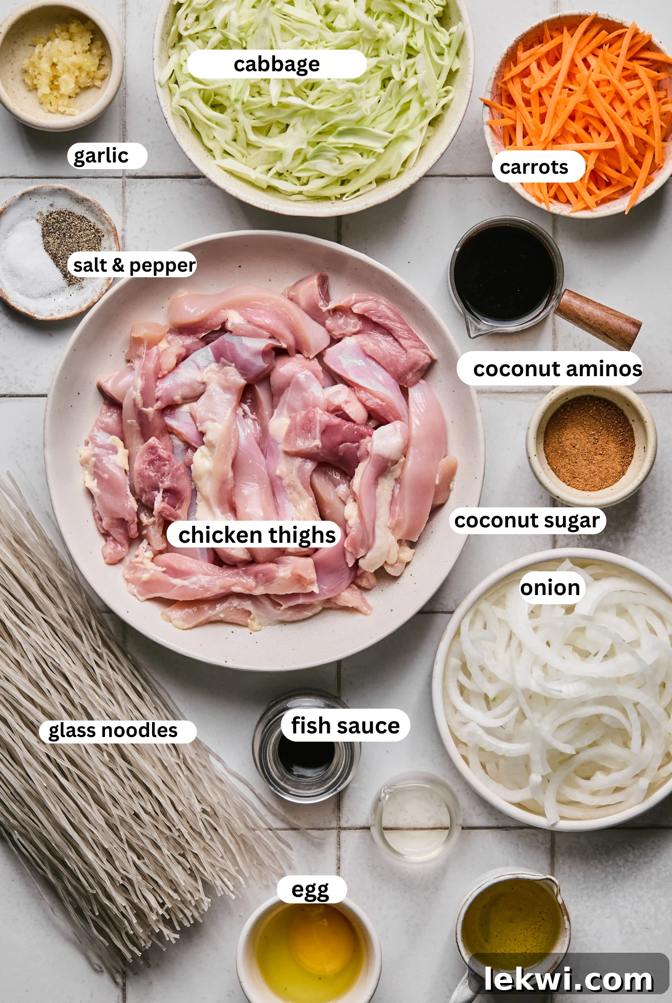 Organized bowls of Pad Woon Sen ingredients including glass noodles, chicken, and various chopped vegetables, ready for preparation.