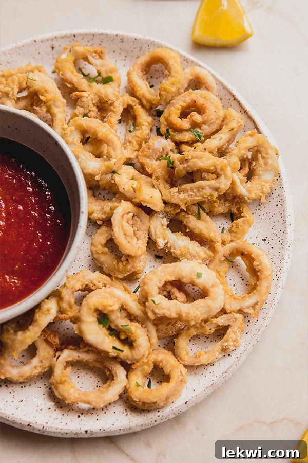Crispy calamari on a plate with marinara sauce.