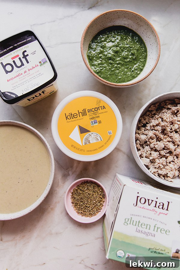 A flat lay photograph displaying all the ingredients for making white pesto lasagna roll-ups, including lasagna sheets, jars of sauce, fresh basil, and ground turkey.