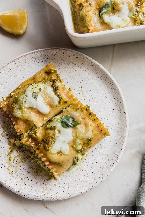 A single serving of white pesto lasagna roll-up on a white plate, garnished with fresh basil, showcasing the layers.