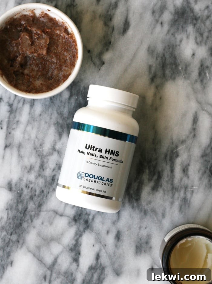 A small jar of homemade vanilla coconut oil and coconut sugar scrub, next to a container of natural tallow balm, emphasizing natural beauty products.