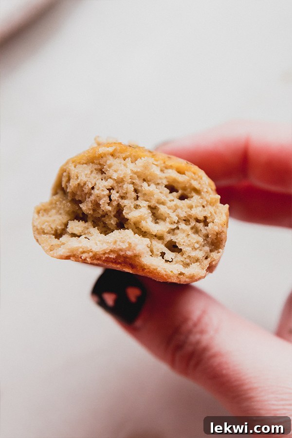 A hand gently holding a warm, fluffy gluten-free breadstick, with a bite already taken, showcasing its irresistibly soft and airy interior.