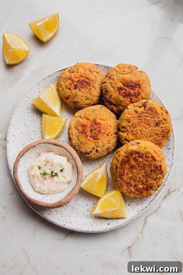 A plate of sweet potato tuna cakes with lemon and dip.