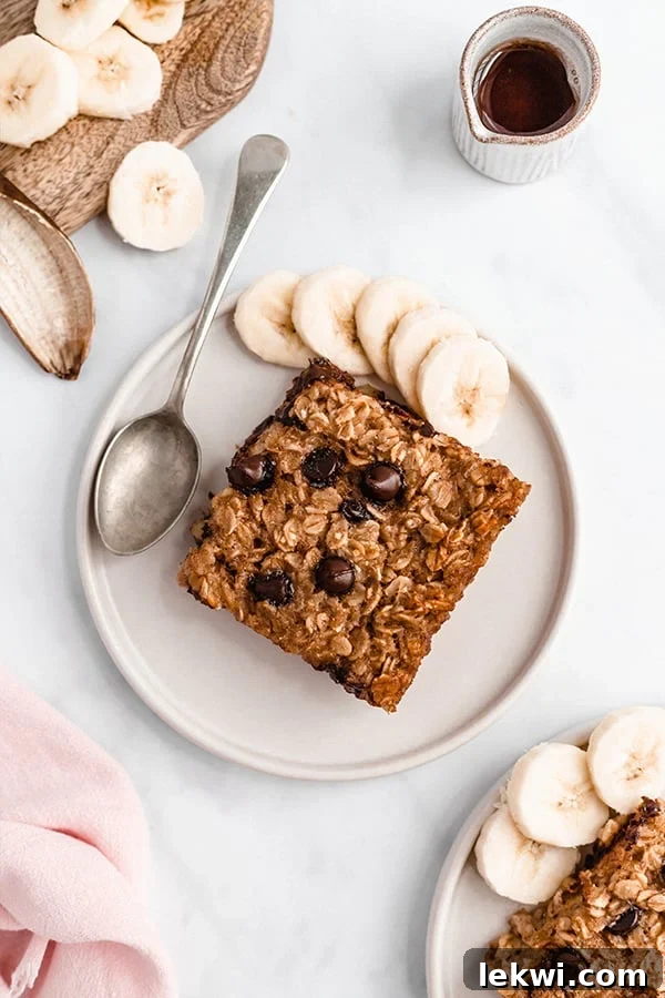 Banana baked oatmeal on a plate with a spoon and banana slices.