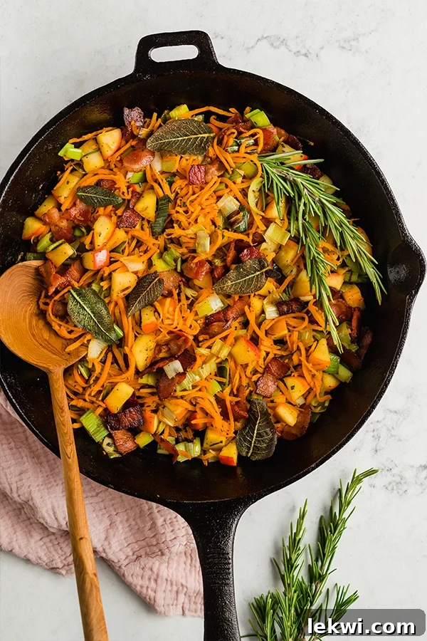Wooden spoon in a skillet of carrot hash.