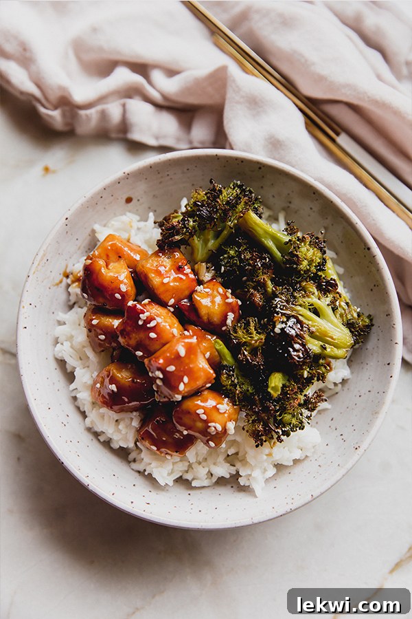 A bowl of sheet pan sesame chicken over rice.