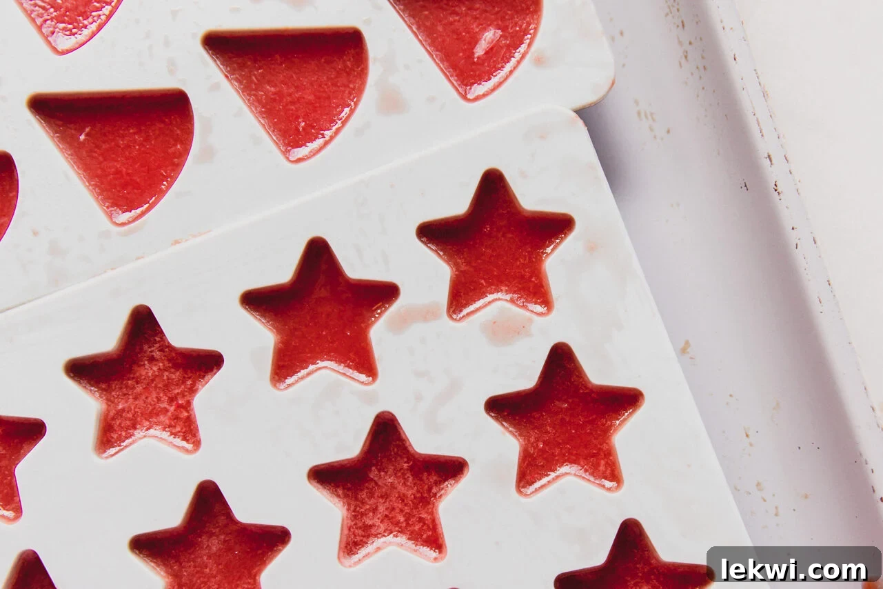 Various sour watermelon gummies setting in star and wedge-shaped silicone molds, ready to chill.