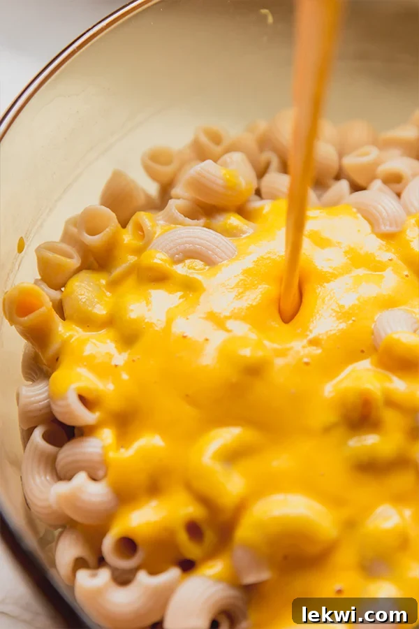 A pot of pasta with sauce being added to it.