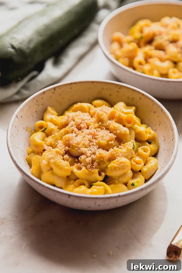 Two bowls of zucchini mac and cheese on a counter.