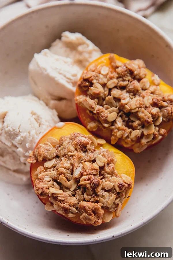 Two scoops of dairy-free ice cream served alongside two golden-brown air fryer peach crisps.