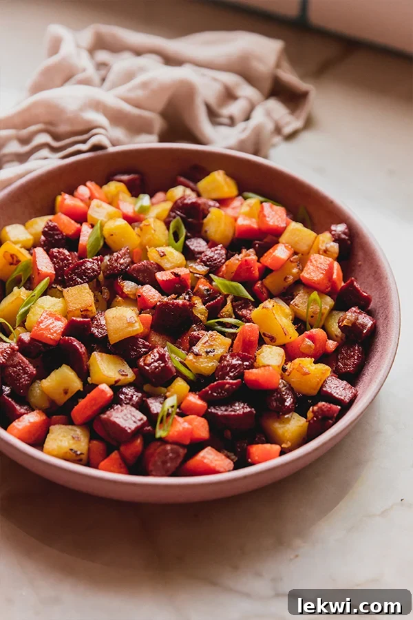 Hot dog and veggie hash in a bowl, garnished with fresh green onions.