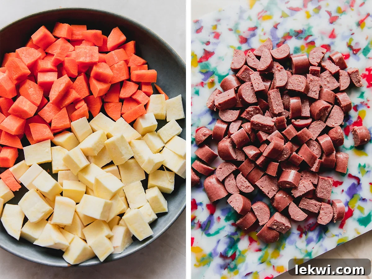 Sliced vegetables (carrots, sweet potatoes, onions) and chopped hot dogs arranged on a cutting board, ready for cooking.