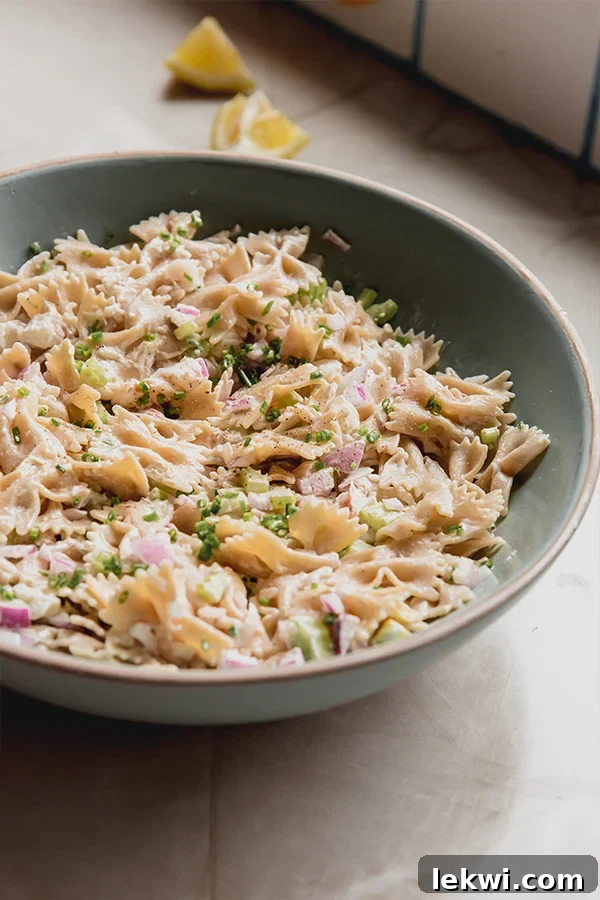 A vibrant bowl of gluten-free lobster roll pasta salad, showcasing tender pasta, succulent lobster, and crisp vegetables, ready to be served.