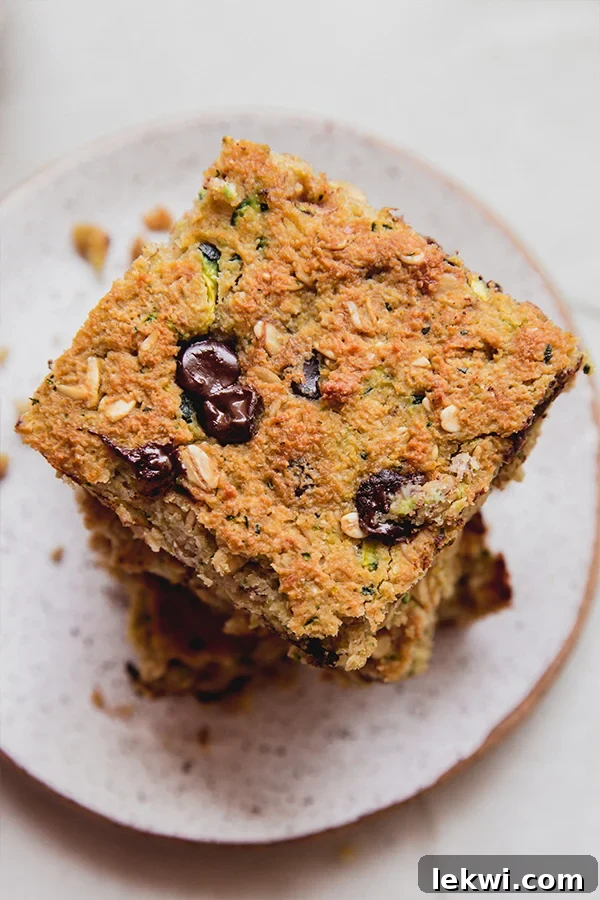 A stack of zucchini banana breakfast bars on a plate ready to enjoy!
