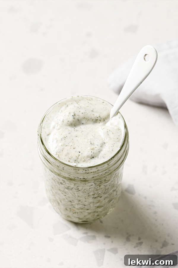 A glass jar filled with freshly blended homemade ranch dressing, ready to be chilled and used in the pasta salad.