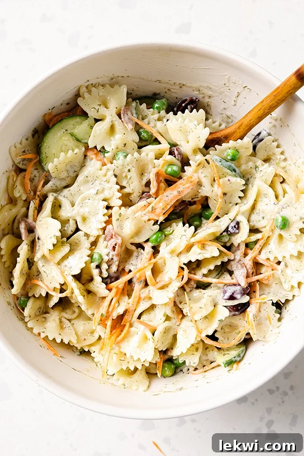 A generous serving of bacon ranch bow-tie pasta salad in a large mixing bowl, ready to be dished out and enjoyed.