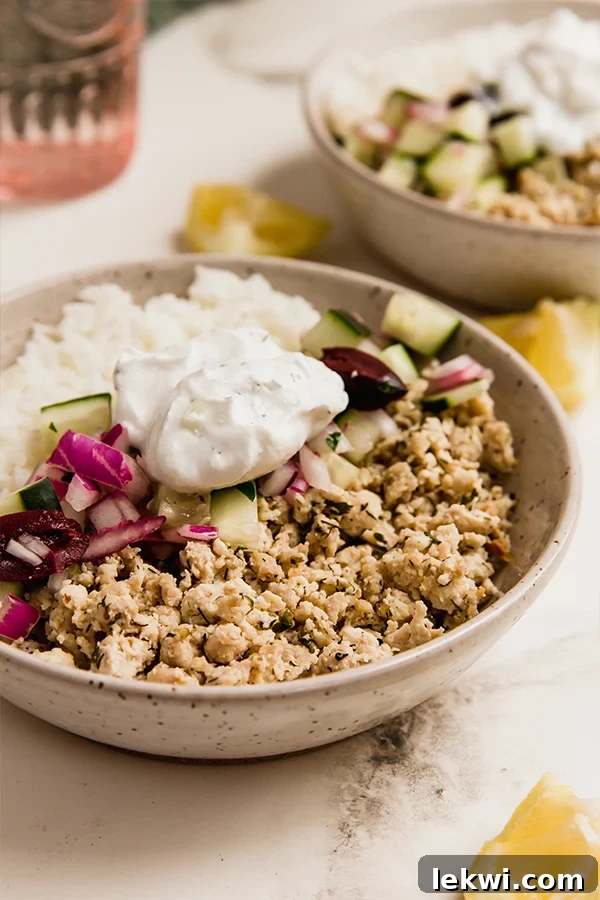 Healthy Greek ground chicken bowl with red onion, cucumber, and olives.