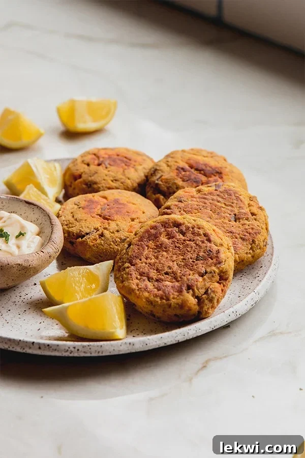 Delicious gluten-free sweet potato tuna cakes on a plate with lemon wedges.