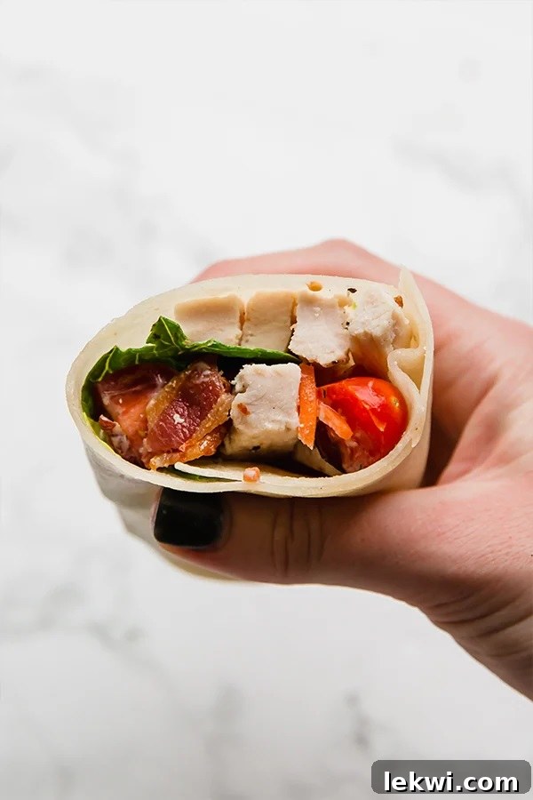 Person holding a delicious paleo chicken bacon ranch wrap.