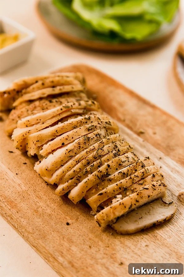 Sliced homemade chicken lunch meat on a cutting board.