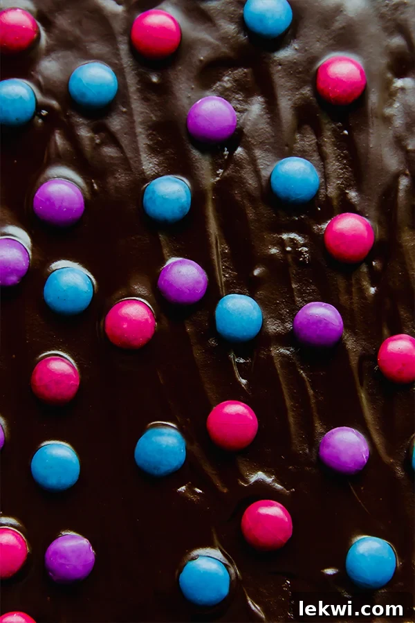 The finished almond flour brownies, topped with a glossy chocolate ganache and vibrant Unreal Crispy Quinoa Gems, capturing the nostalgic 'cosmic' look.