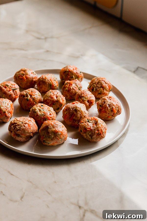 Wholesome Hidden Veggie Meatballs Gluten and Dairy Free 4 A plate filled with raw, uniformly sized hidden veggie meatballs, ready for cooking.