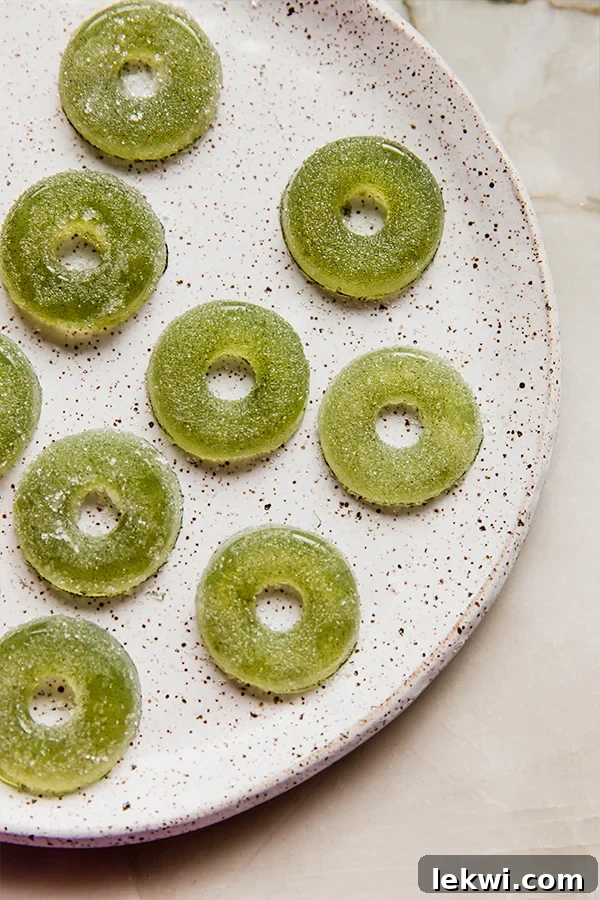Plate with several sour apple ring gummies.