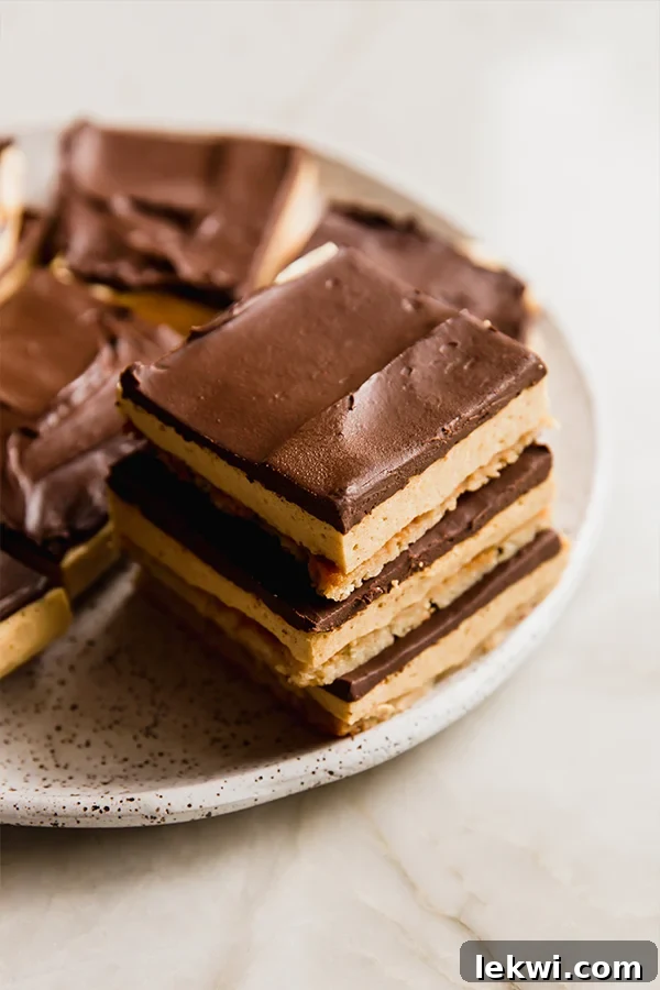 Cozy Gluten-Free Dairy-Free Pumpkin Spice S'mores Bars 6 Stacked pumpkin spice s'mores bars on a white plate, ready to be served and enjoyed.