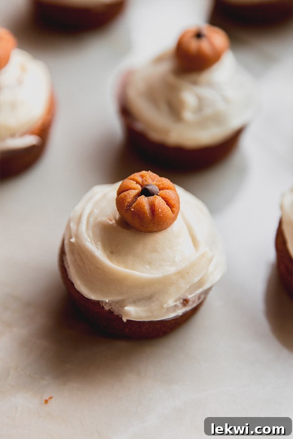 Pumpkin spice cupcakes sitting on a counter after being decorated.