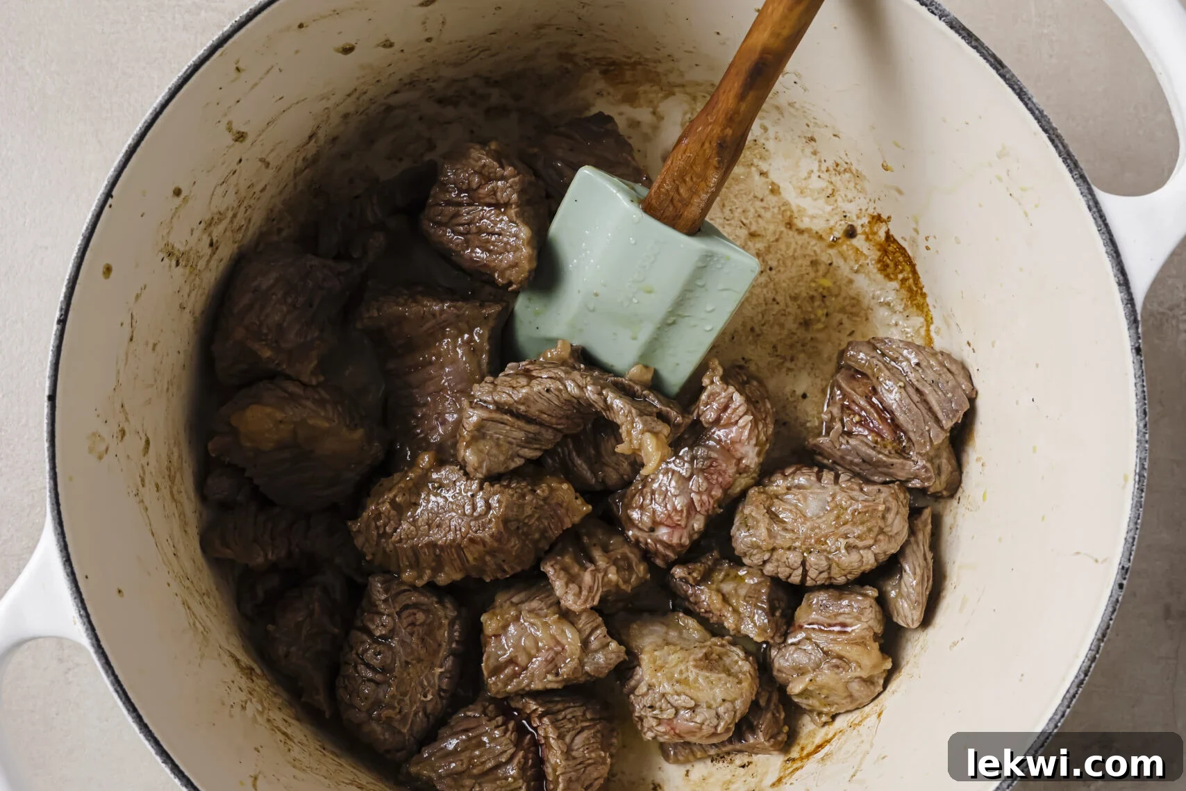 Beef stew meat cooked in a pot.