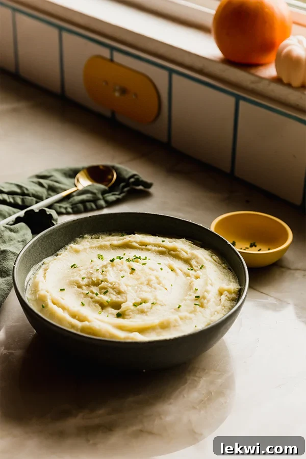 A rustic bowl of instant pot mashed white sweet potatoes, garnished with fresh herbs, resting on a wooden counter, ready to be enjoyed.