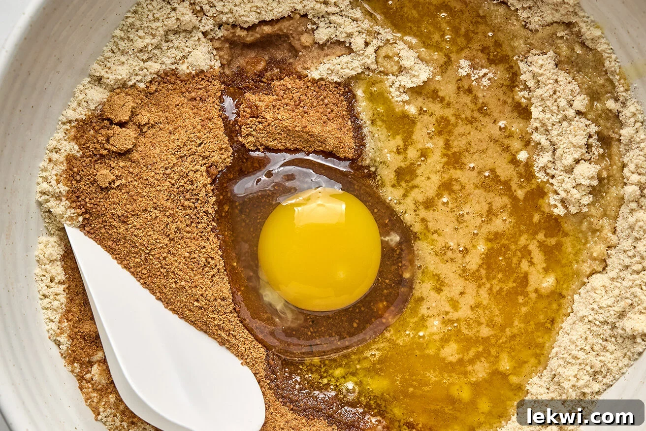 Dry ingredients for the cookie base, including almond flour, arrowroot starch, and pumpkin pie spice, resting unmixed in a bowl.
