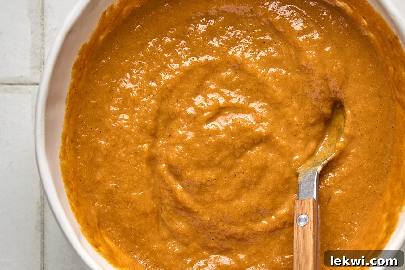 The pumpkin pie layer ingredients, thoroughly mixed into a smooth, creamy, and vibrant orange batter, ready for layering.