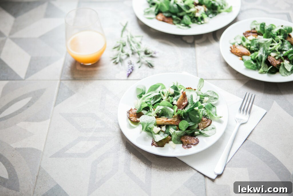 Salad with arugula on a plate with a glass of orange juice.