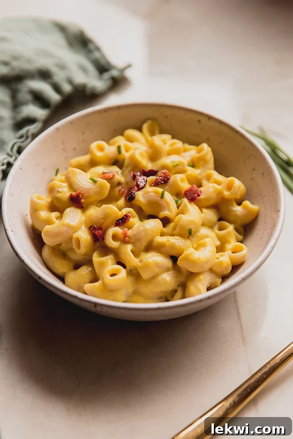 A close-up shot of a bowl of dairy-free pumpkin mac and cheese, perfectly garnished and ready to be enjoyed.