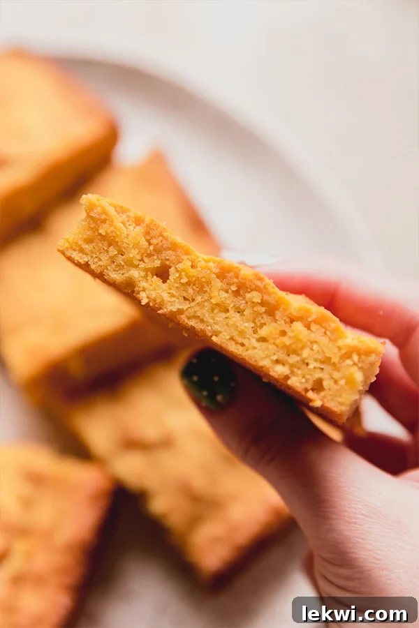 Person holding a piece of "corn" bread.