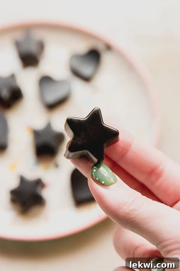 Person holding a star-shaped elderberry gummy.