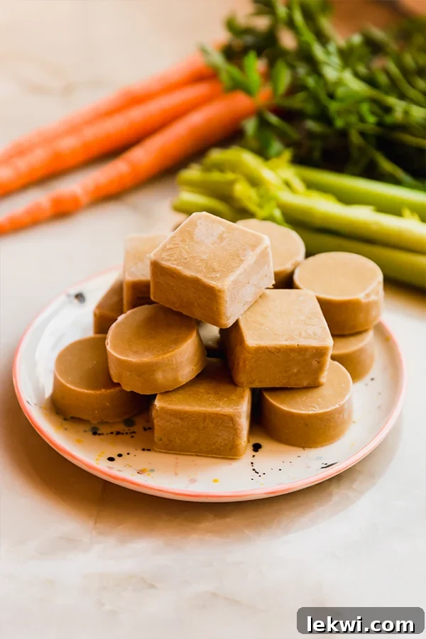 A stack of homemade beef bouillon cubes on a white plate, showcasing their rustic, natural appearance.