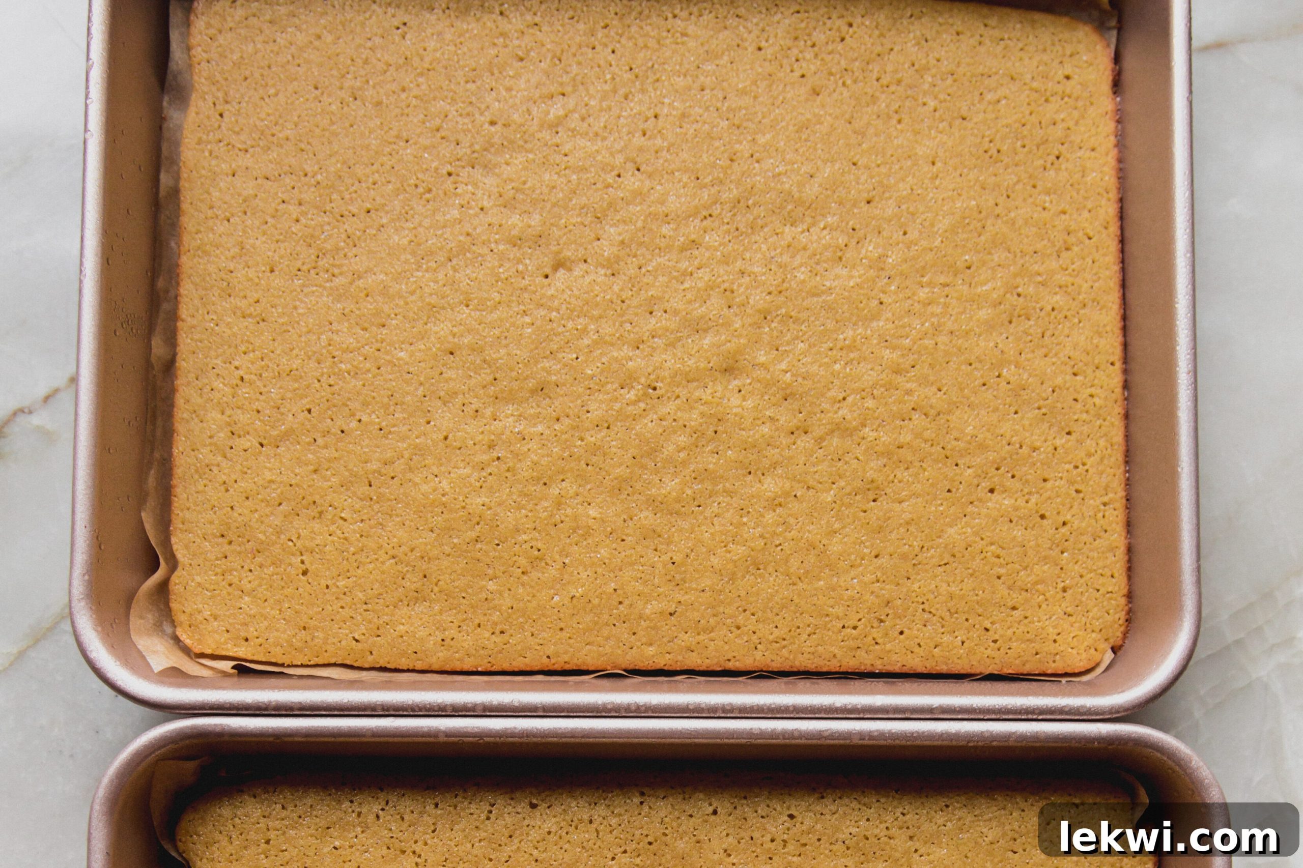 Freshly baked Christmas tree cake batter cooling in two pans.