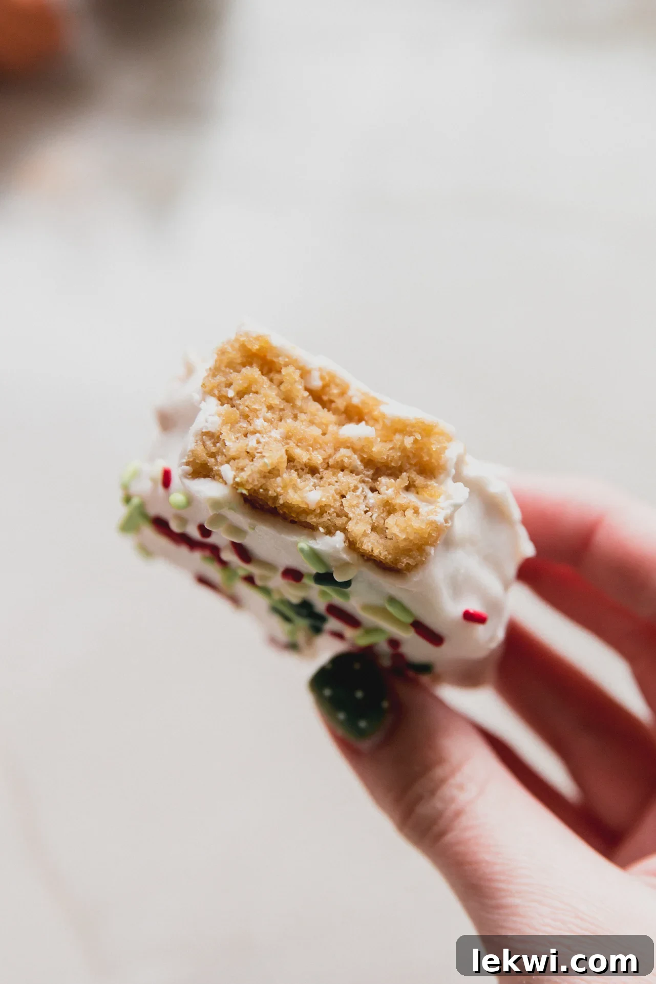 A gluten-free Christmas tree cake with a bite taken out, showcasing the marshmallow filling and white chocolate coating.