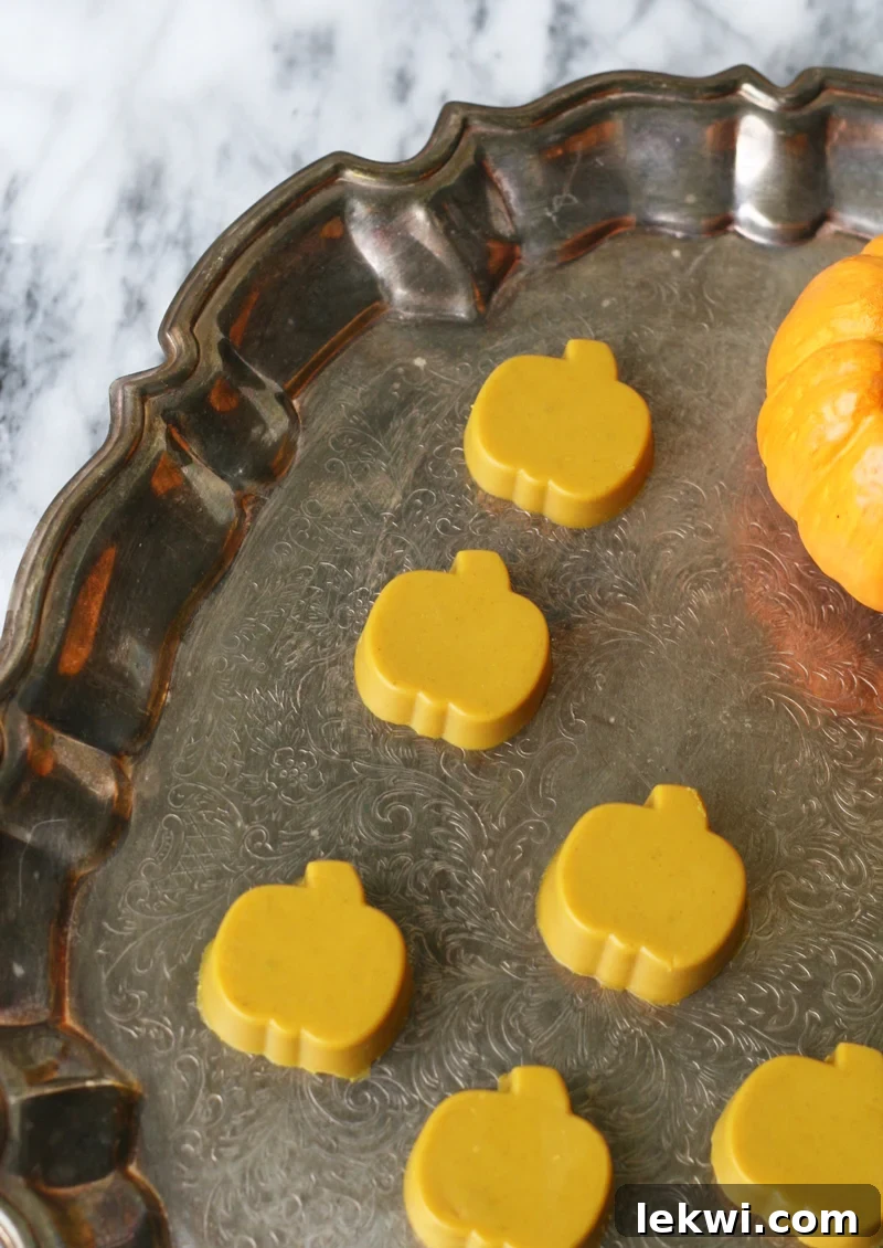 Turmeric gummies in a pumpkin shape on a brass platter.