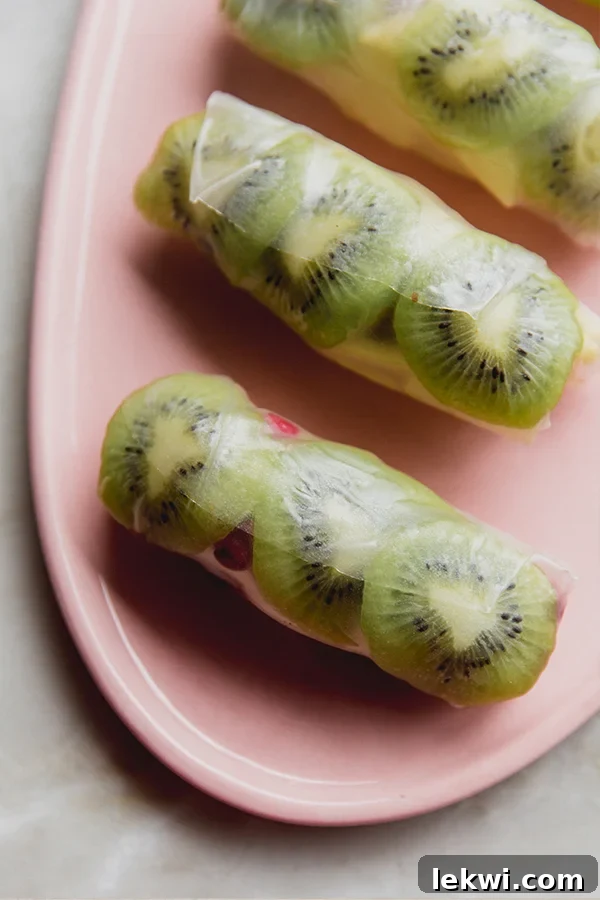 Kiwi and other colorful winter fruits beautifully arranged in delicate rice paper wrappers, highlighting a fresh, healthy snack.