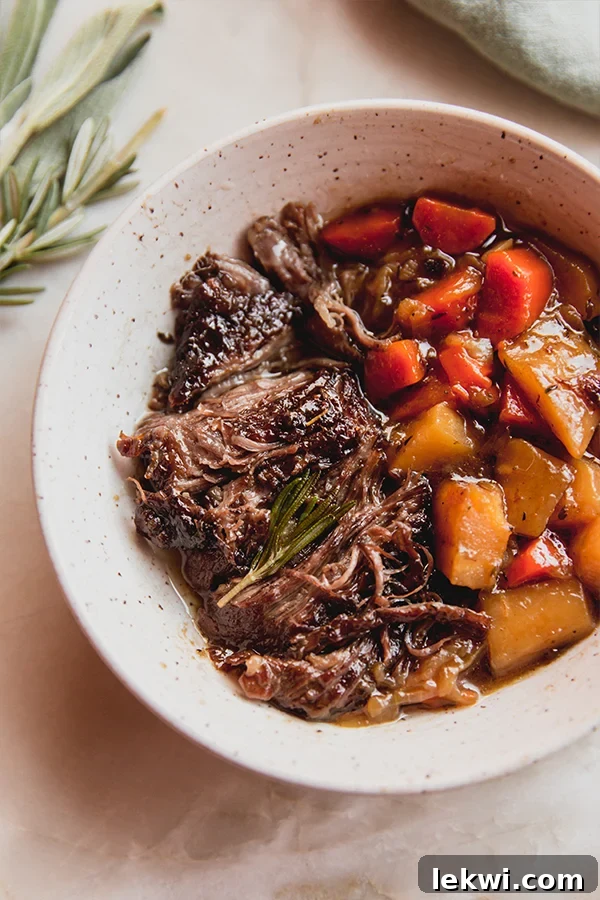 Carrots, parsnips, and cider-braised pot roast in a dish.