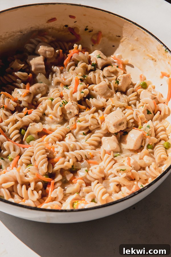 The finished one-pot Chicken Pot Pie Pasta, brimming with tender pasta, succulent chicken, and colorful vegetables in a rich, creamy sauce.