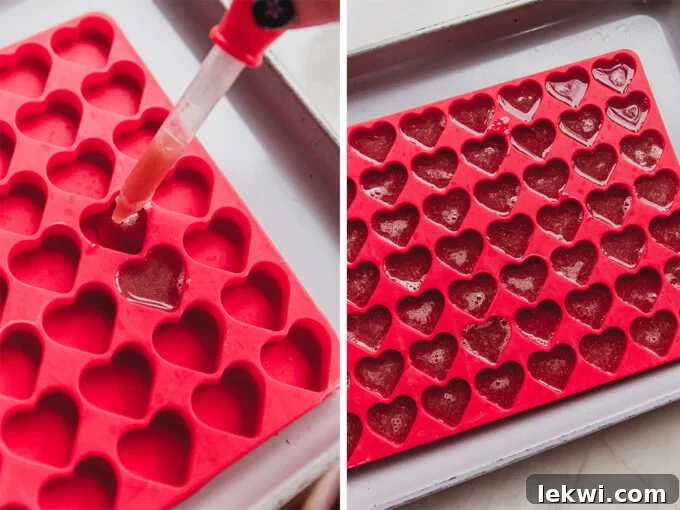 Dropper filling a mini heart mold with fruit mixture.