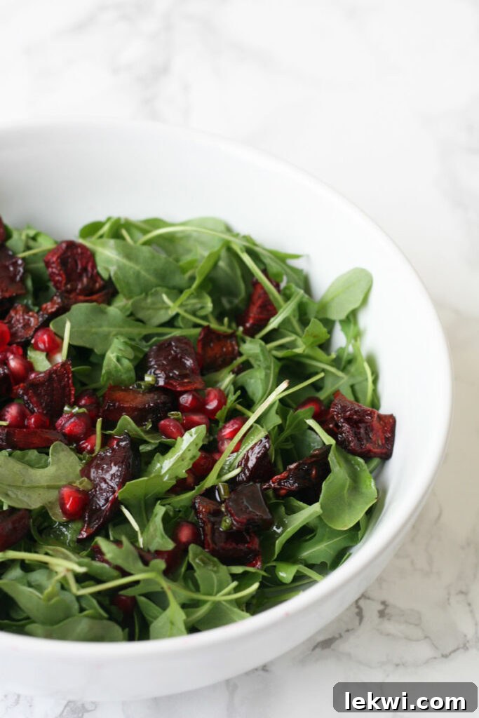 Jeweled Fall Pomegranate Beet Salad AIP Paleo Vegan Friendly 3 Close-up of roasted beets and pomegranate seeds on fresh arugula, highlighting the delicious textures and vibrant colors of the Pomegranate Beet Fall Salad.