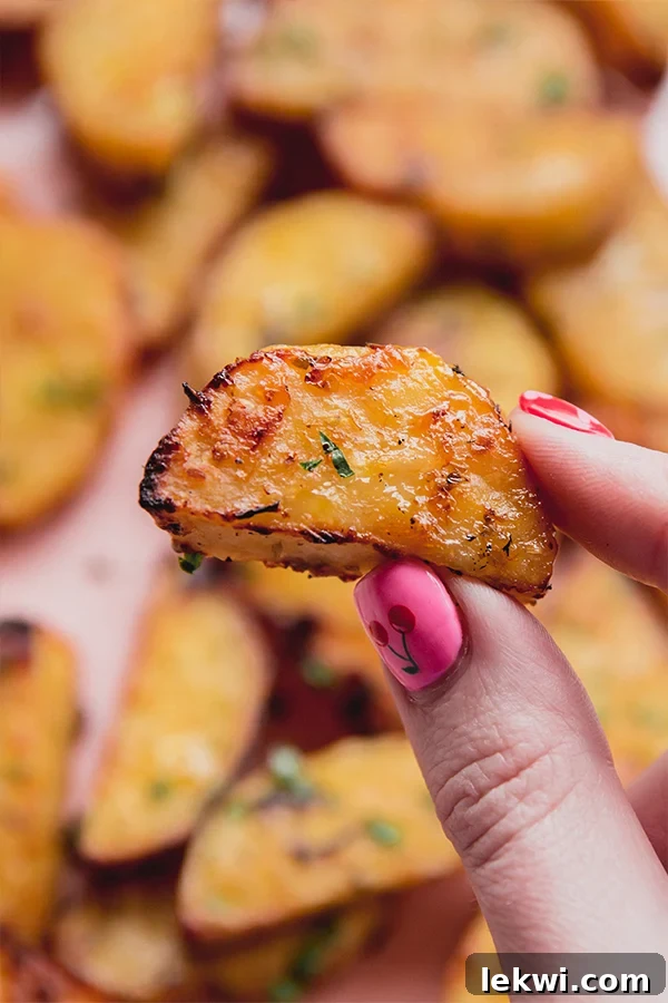 One Greek lemon style sweet potato being held in a hand, showing its golden-brown crisp exterior.