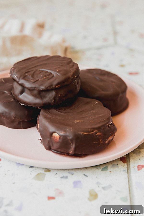 Four gluten free moon pies stacked on a pink plate.